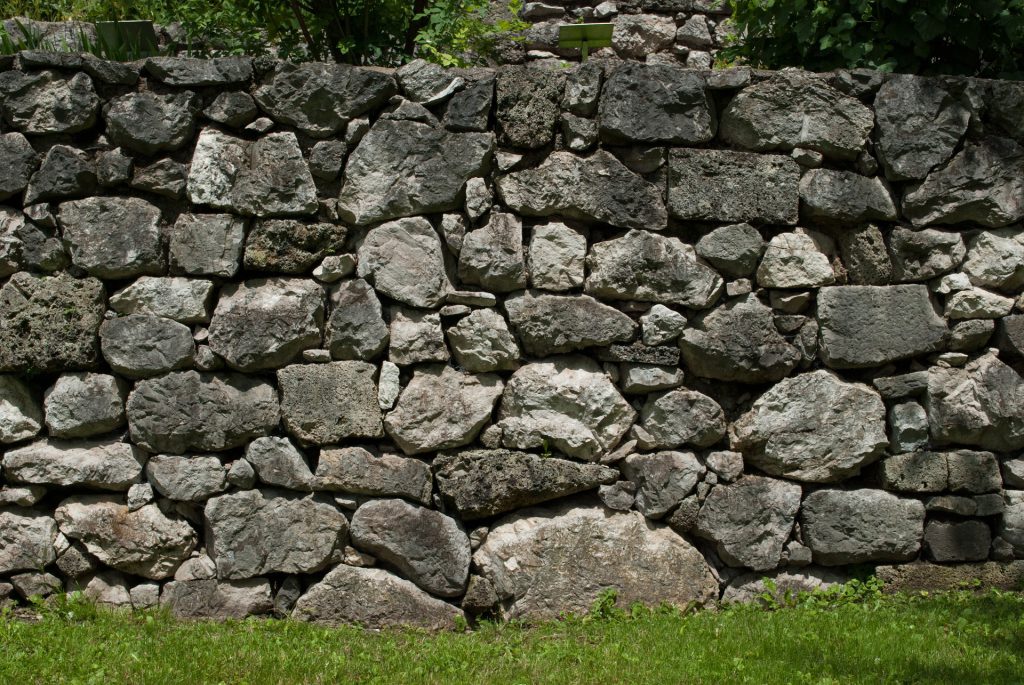 Un mur en pierres naturelles dans un jardin