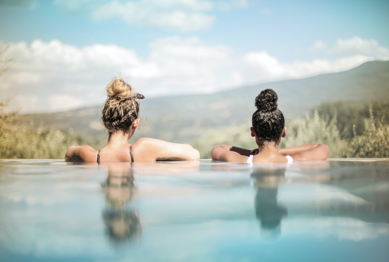 deux femmes accoudées au bord d'une piscine