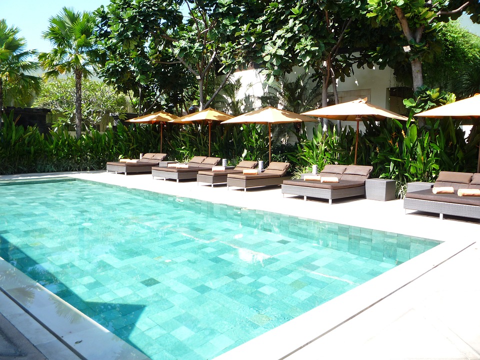 Piscine entourée d'un jardin et de chaises longues